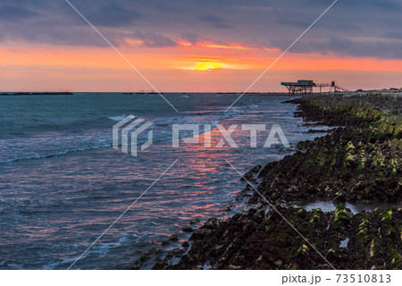 Rocky coastline on sea at sunrise Rocky coastline on sea at sunrise 73510813