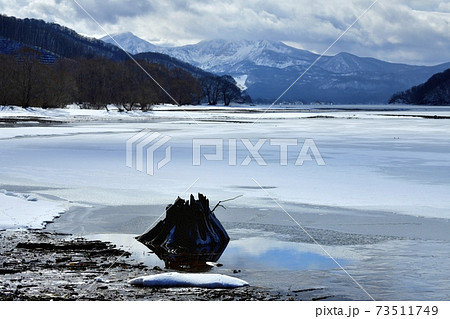 裏磐梯桧原湖・結氷の湖面に雪模様と朽木に磐梯山 73511749
