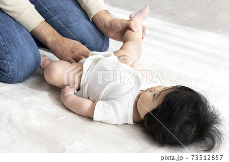 赤ちゃんの紙おむつ交換する父親 0歳 生後6ヶ月 女の子 日本人 の写真素材