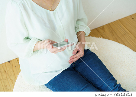 スマホを見る女性 マタニティ スマホを見る女性 マタニティ 73513813