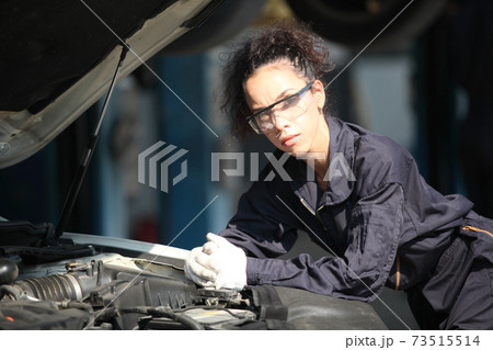 Portrait of a mechanic at work in his garage or car repair service or auto store, business, maintenance and people concept 73515514