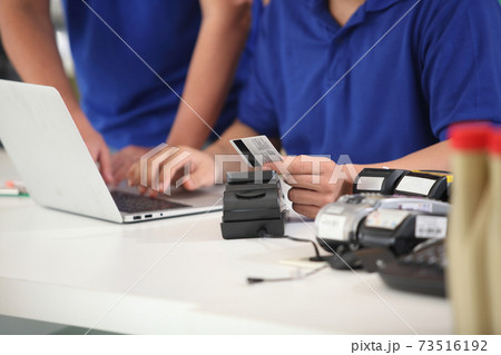 customer paying with  credit card with  technology. credit card reader machine at bar counter with  holding credit card. Focus on hands. 73516192