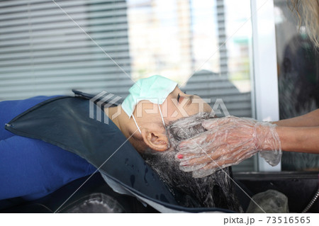 woman customer in a salon with medical masks during virus pandemic. Working with safety mask. woman customer in a salon with medical masks during virus pandemic. Working with safety mask. 73516565