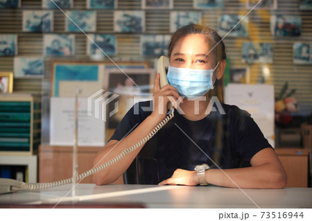 Young woman with face mask back at work in office after lockdown 73516944