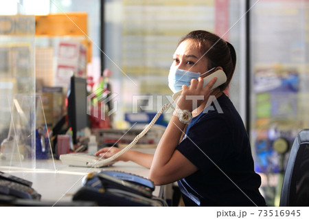 Young woman with face mask back at work in office after lockdown 73516945
