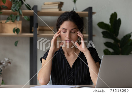 Tired young woman overwhelmed with computer work 73518099
