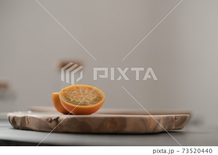 Lulo fruit sliced in halves on olive wood board on kitchen countertop Lulo fruit sliced in halves on olive wood board on kitchen countertop 73520440