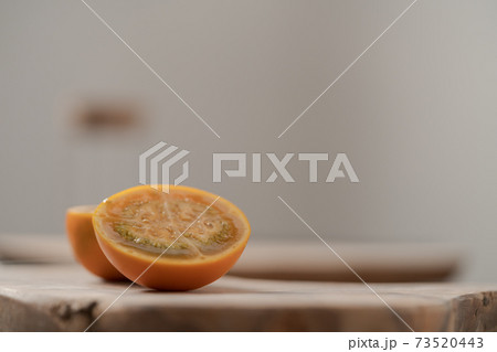 Lulo fruit sliced in halves on olive wood board on kitchen countertop 73520443