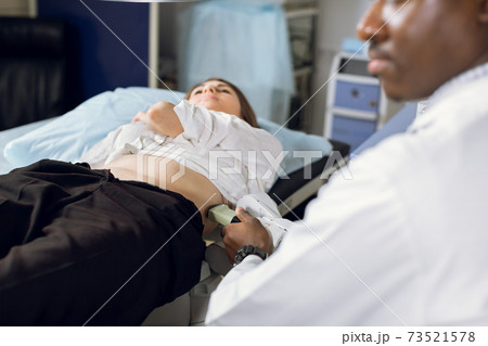 Extracorporeal shockwave therapy in urology. Cropped shot of lying woman patient, having ultrasound diagnostics to determine kidney stones position before the lithotripsy procedure. 73521578