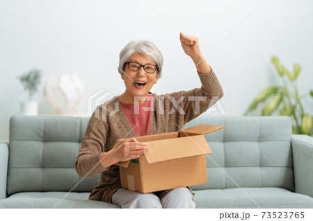 senior woman is holding cardboard box 73523765