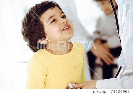 Woman-doctor examining a child patient by stethoscope. Cute arab boy at physician appointment. Medicine help concept Woman-doctor examining a child patient by stethoscope. Cute arab boy at physician appointment. Medicine help concept 73524965