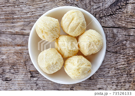 Bowl of frozen potato balls on wood, from above 73526133