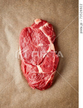 Raw beef steak on recycling paper, from above Raw beef steak on recycling paper, from above 73526922