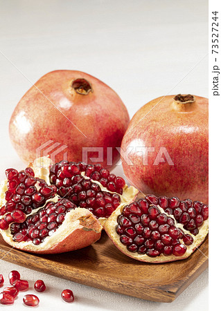 白い木目テーブルの上に置いたザクロの写真素材