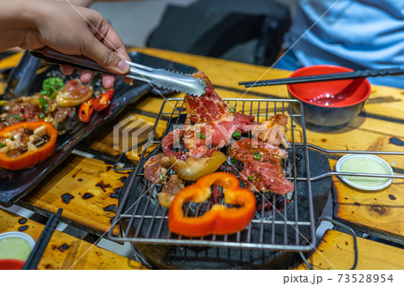 Grilling marinated meat slices and bell pepper on charcoal stove 73528954