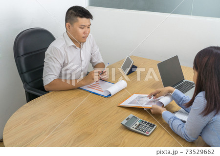 Asian manager disagree with employee about idea on report 73529662