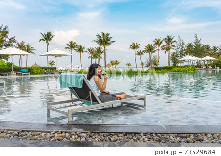 Young Asian woman enjoy red wine at beautiful swimming pool Young Asian woman enjoy red wine at beautiful swimming pool 73529684