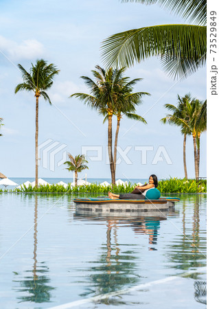 Young woman enjoy summer time at beautiful infinity swimming pool 73529849
