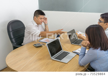 Asian businessman having meeting with his business partners at workplace 73529864