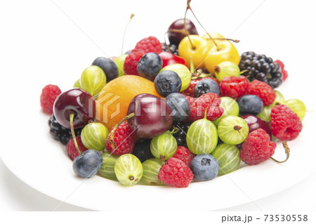 assortment of fresh berries on a white plate. useful vitamin healthy food fruit. assortment of fresh berries on a white plate. useful vitamin healthy food fruit. 73530558