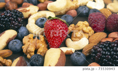 different berries and nuts on a plate. vitamin proteins and healthy foods different berries and nuts on a plate. vitamin proteins and healthy foods 73530943