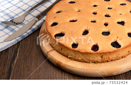 Blackberry pie on a cutting board over a wooden background. 73532424