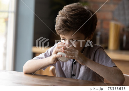 Little boy child drink organic milk from glass 73533653