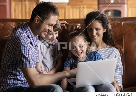 Overjoyed family with kids watch video on laptop Overjoyed family with kids watch video on laptop 73533714