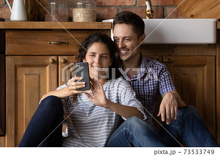 Happy man and woman relax using cellphone at home 73533749