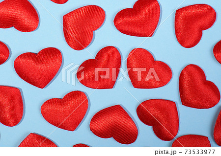 Pattern made of red hearts of the cloth on a pastel blue background 73533977