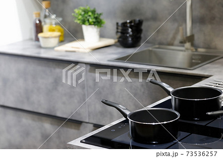 modern kitchen with non-stick saucepans 73536257