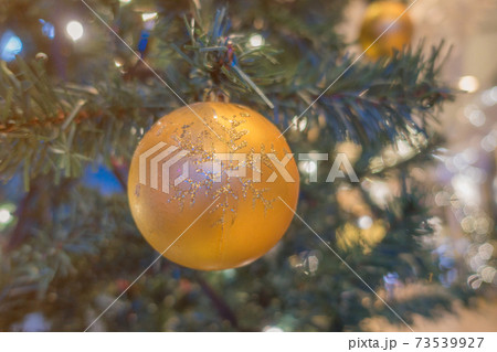 Orange ball decorated Christmas tree decorated with lights at night. 73539927