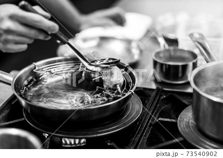 Chef cooking in a kitchen, chef at work, Black and White. Chef cooking in a kitchen, chef at work, Black and White. 73540902