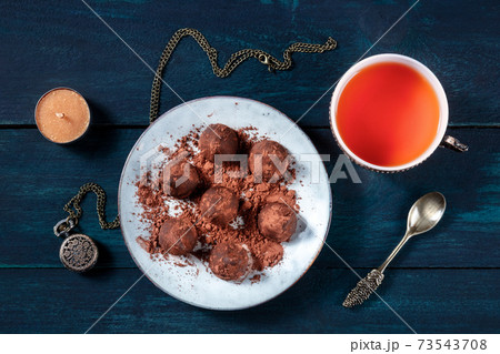 Chocolate truffles on a plate, with tea, overhead flat lay shot 73543708