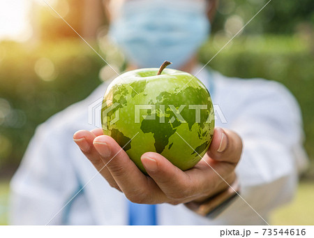 World health day, an apple a day keeps the doctor away concept for health benefit by eating high nutritious clean food and healthy nutritional diet with doctor handling green apple giving to patient 73544616