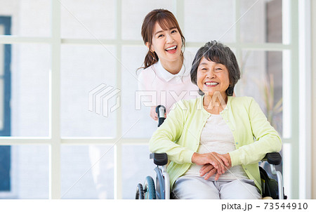 介護施設の高齢者と若いスタッフの女性 73544910