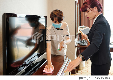 Hotel manager controlling cleaning maid Hotel manager controlling cleaning maid 73545403