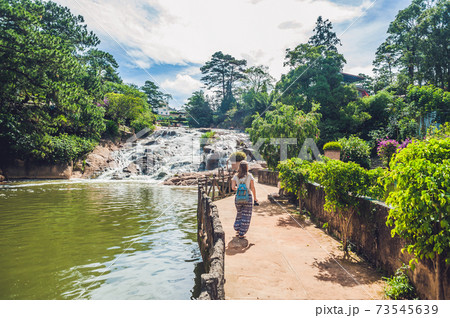 Young woman on the background of Beautiful Camly waterfall In Da Lat city 73545639