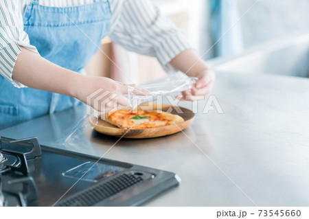 料理にラップをする主婦 73545660