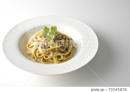 三つ葉が乗っている熱々トリュフクリームの平打ちパスタを白背景で撮影 73545870