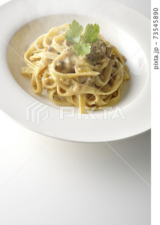三つ葉が乗っている熱々トリュフクリームの平打ちパスタを白背景で撮影 73545890