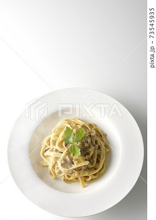 三つ葉が乗っている熱々トリュフクリームの平打ちパスタを白背景で撮影（俯瞰） 73545935