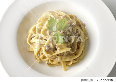 三つ葉が乗っている熱々トリュフクリームの平打ちパスタを白背景で撮影（俯瞰） 73545940
