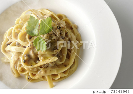 三つ葉が乗っている熱々トリュフクリームの平打ちパスタを白背景で撮影（俯瞰） 73545942
