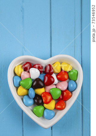 Multicolored candies in a plate in the shape of a heart . Multicolored candies in a plate in the shape of a heart . 73546952