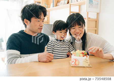 男の子の子育てイメージ 誕生日ケーキと家族 2歳児と両親の写真素材