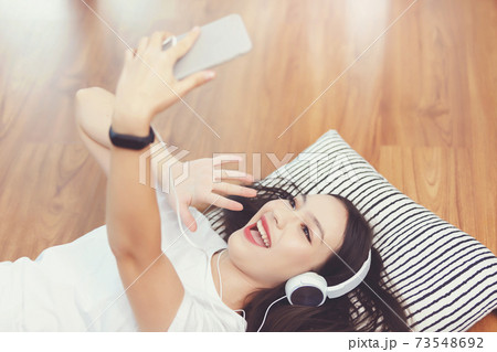 Asian woman lying down on floor in living room, Asian woman lying down on floor in living room, 73548692