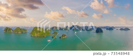 Aerial view panorama of floating fishing village and rock island, Halong Bay, Vietnam, Southeast Asia. UNESCO World Heritage Site. Junk boat cruise to Ha Long Bay. Popular landmark of Vietnam Aerial view panorama of floating fishing village and rock island, Halong Bay, Vietnam, Southeast Asia. UNESCO World Heritage Site. Junk boat cruise to Ha Long Bay. Popular landmark of Vietnam 73548948