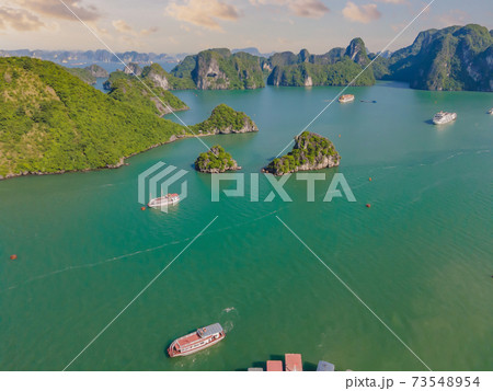 Aerial view panorama of floating fishing village and rock island, Halong Bay, Vietnam, Southeast Asia. UNESCO World Heritage Site. Junk boat cruise to Ha Long Bay. Popular landmark of Vietnam Aerial view panorama of floating fishing village and rock island, Halong Bay, Vietnam, Southeast Asia. UNESCO World Heritage Site. Junk boat cruise to Ha Long Bay. Popular landmark of Vietnam 73548954