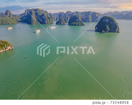 Aerial view panorama of floating fishing village and rock island, Halong Bay, Vietnam, Southeast Asia. UNESCO World Heritage Site. Junk boat cruise to Ha Long Bay. Popular landmark of Vietnam Aerial view panorama of floating fishing village and rock island, Halong Bay, Vietnam, Southeast Asia. UNESCO World Heritage Site. Junk boat cruise to Ha Long Bay. Popular landmark of Vietnam 73548958